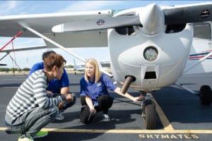 A flight instructor showing her students how to walk around an aircraft for pilot training